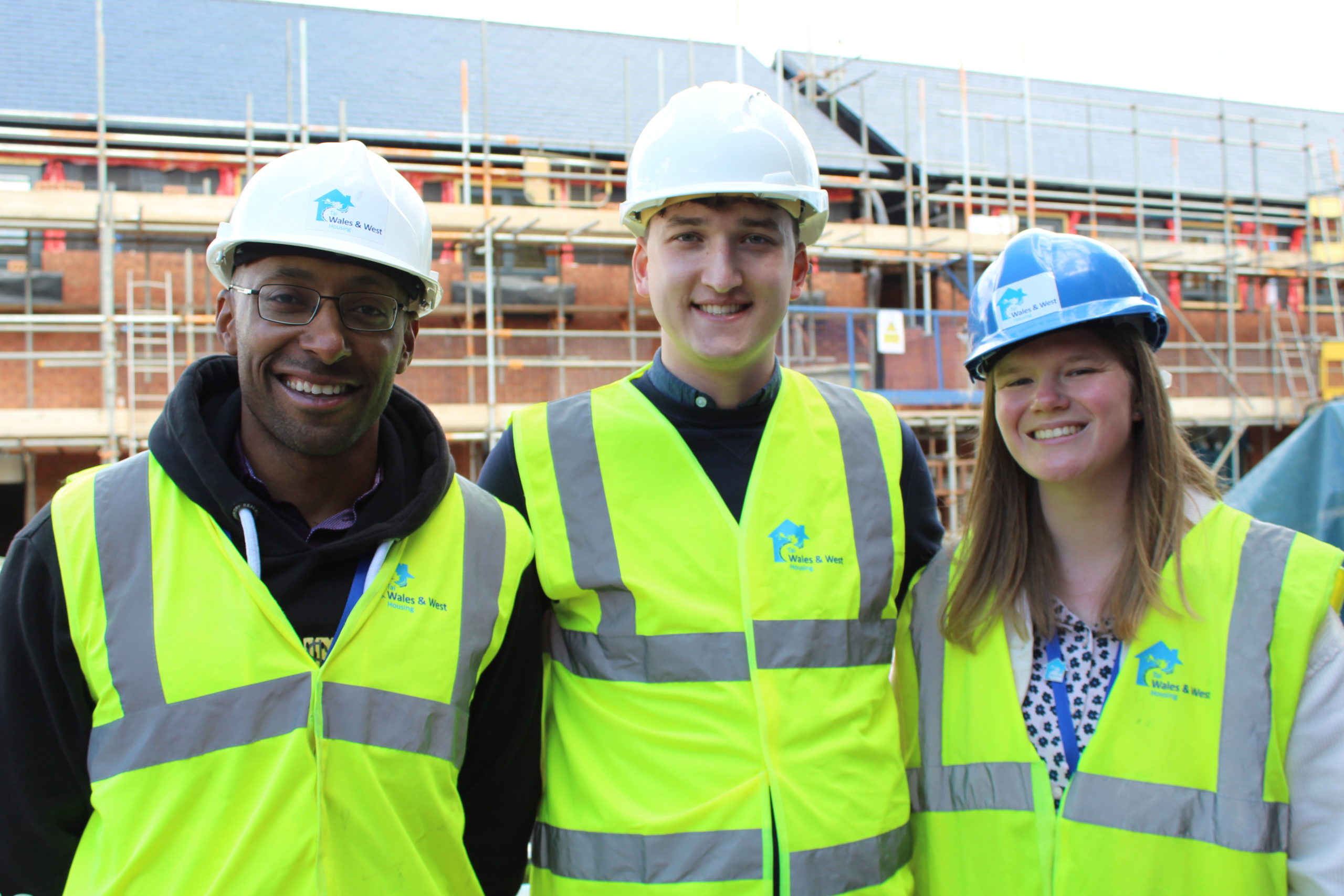 Faizal, Luke and Rachel on a WWH construction site in Northop wearing hard hats and hi-visibility vests