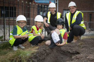 WWH staff and pupils from Ysgol Owen Jones burying a time capsule