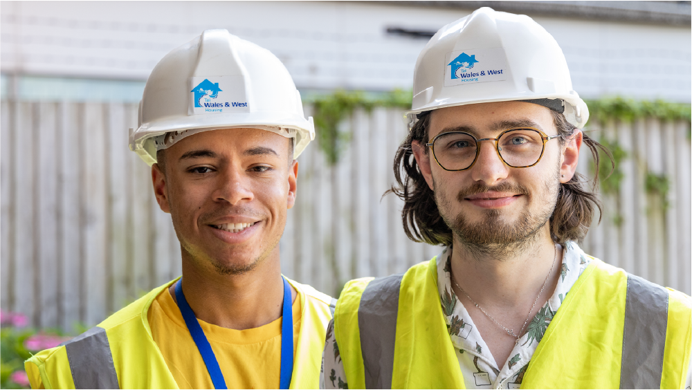 Two young WWH staff members in PPE looking to camera