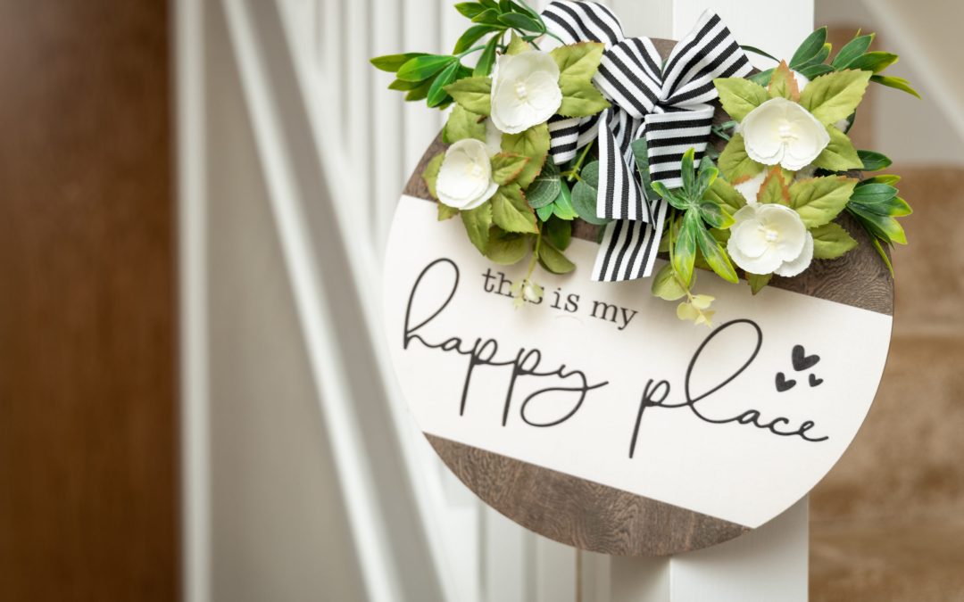 Ornament hanging on banister that reads ‘thihs is my happy place’