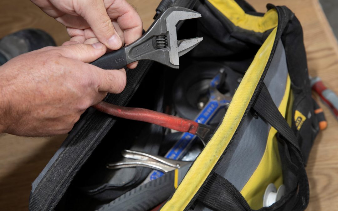 Persons hands taking ajdustable wrench from a toolbox