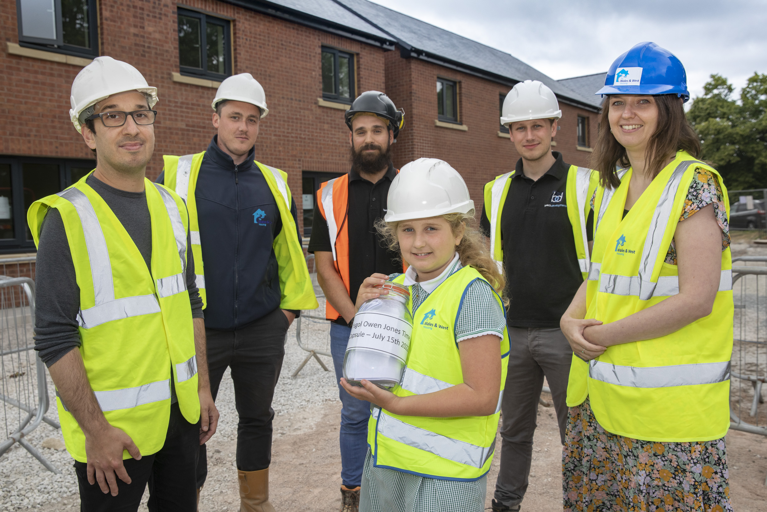 WWH staff with students from Northop school burying a time capsule on a construction site