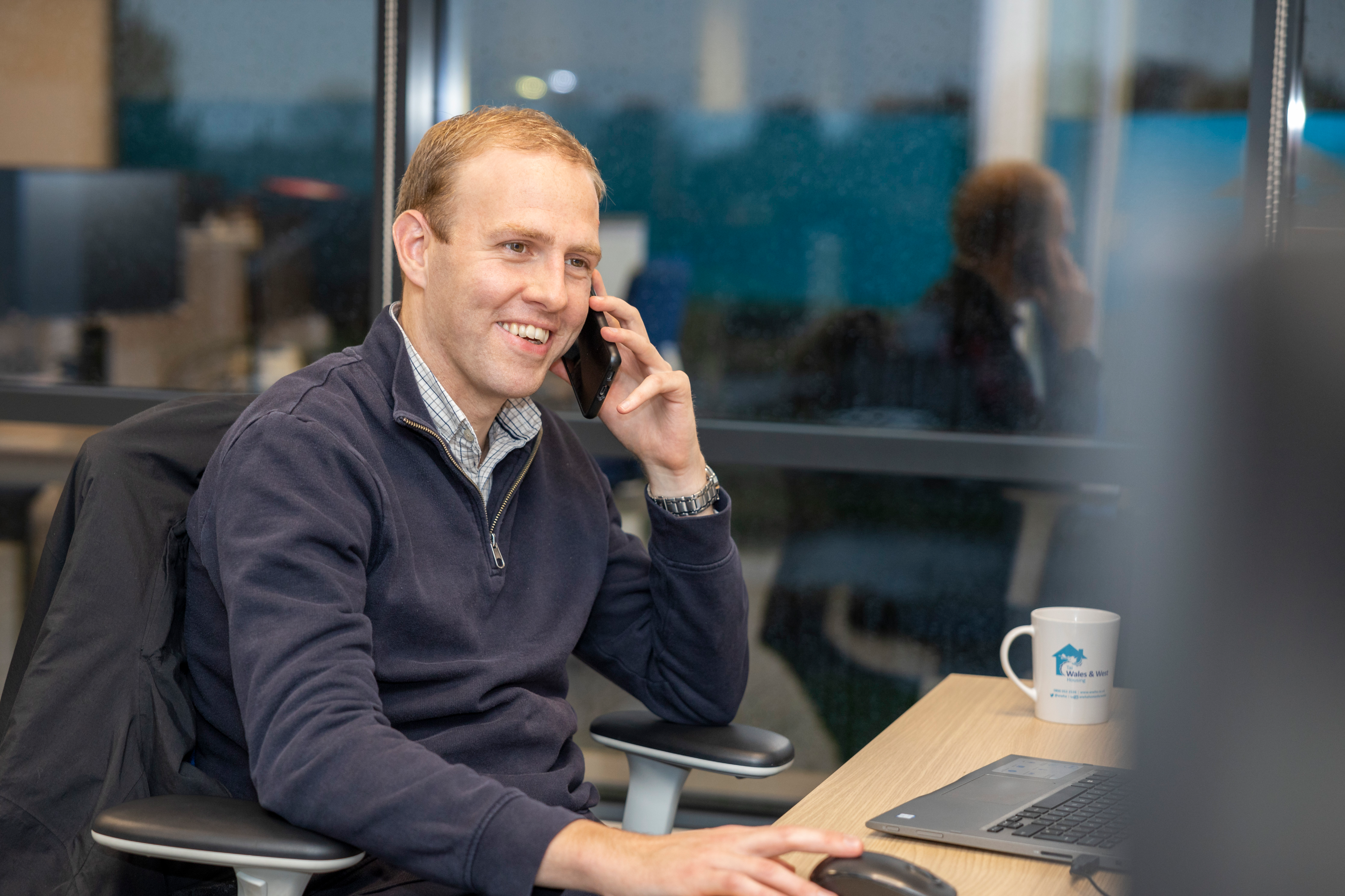 WWH staff member smiling whilst talking on a headset