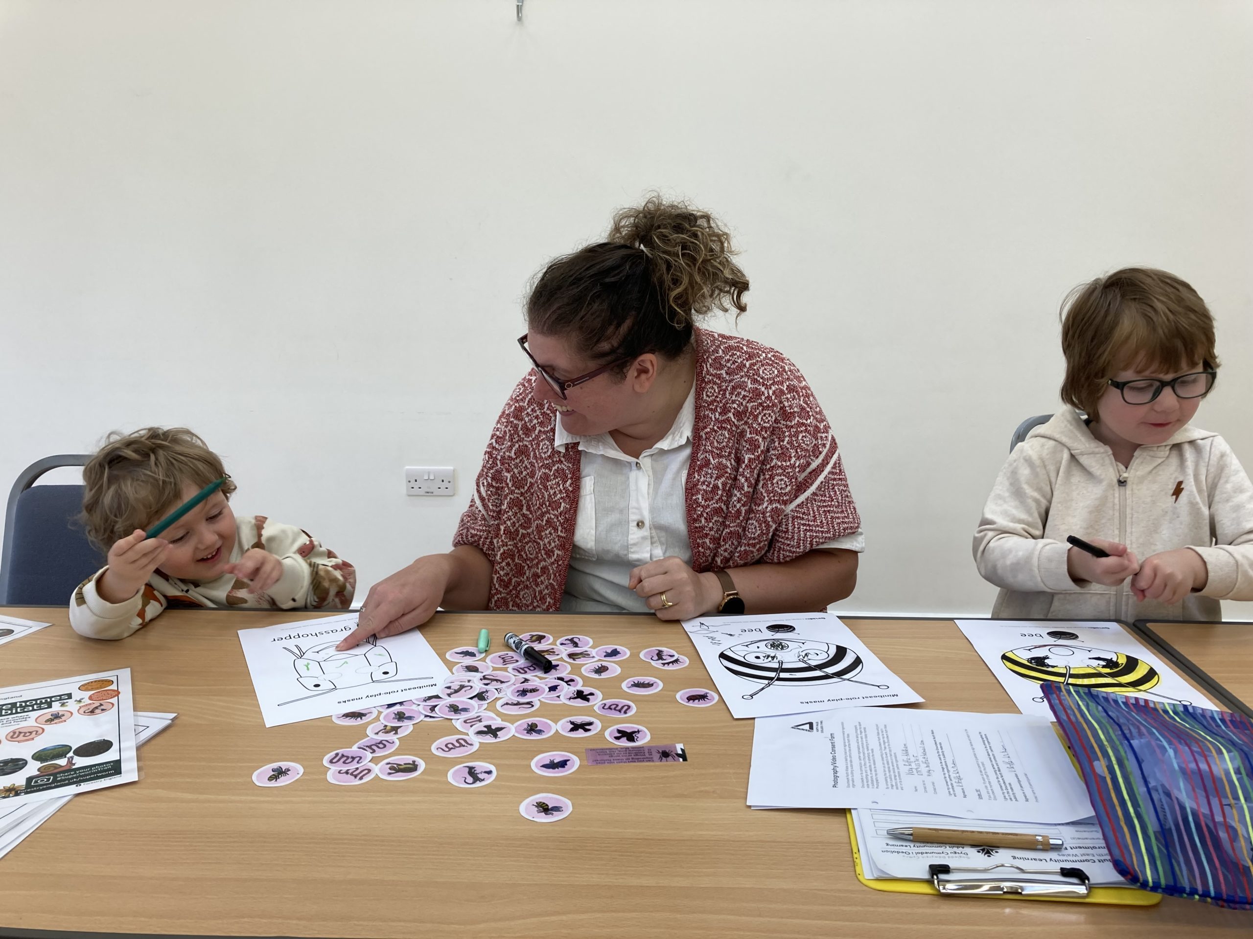 Parent helping child with colouring in activity